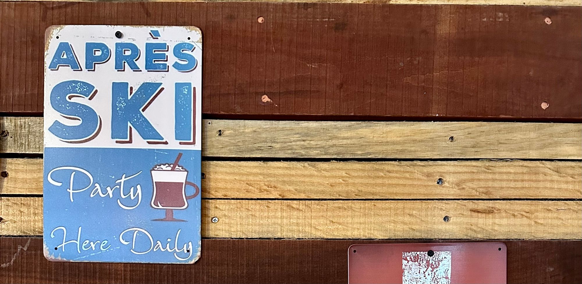 Classic wall sign that reads, “après-ski party here daily”